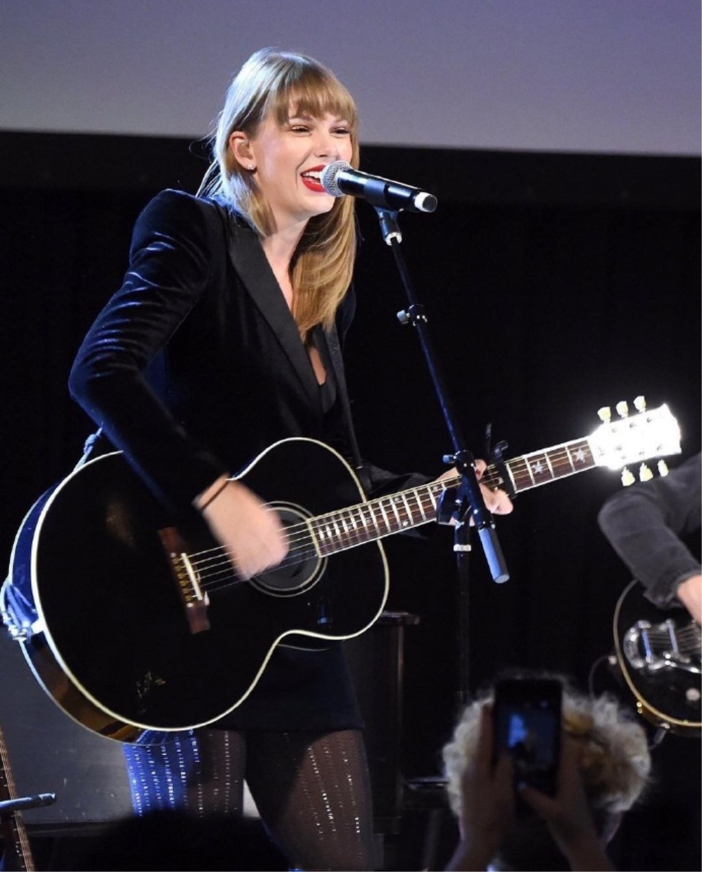 在现场,霉霉背着吉他弹唱,姿势满分,帅气十足,一边弹吉他,一边深情地