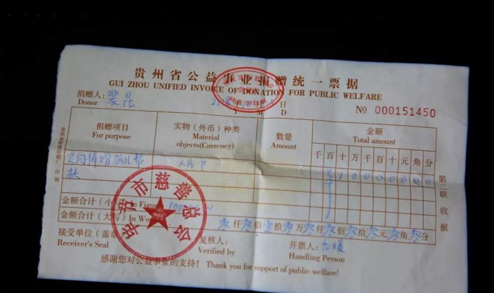 是原贵州软木厂退休职工,手里拿的是一张10万元的捐款收据