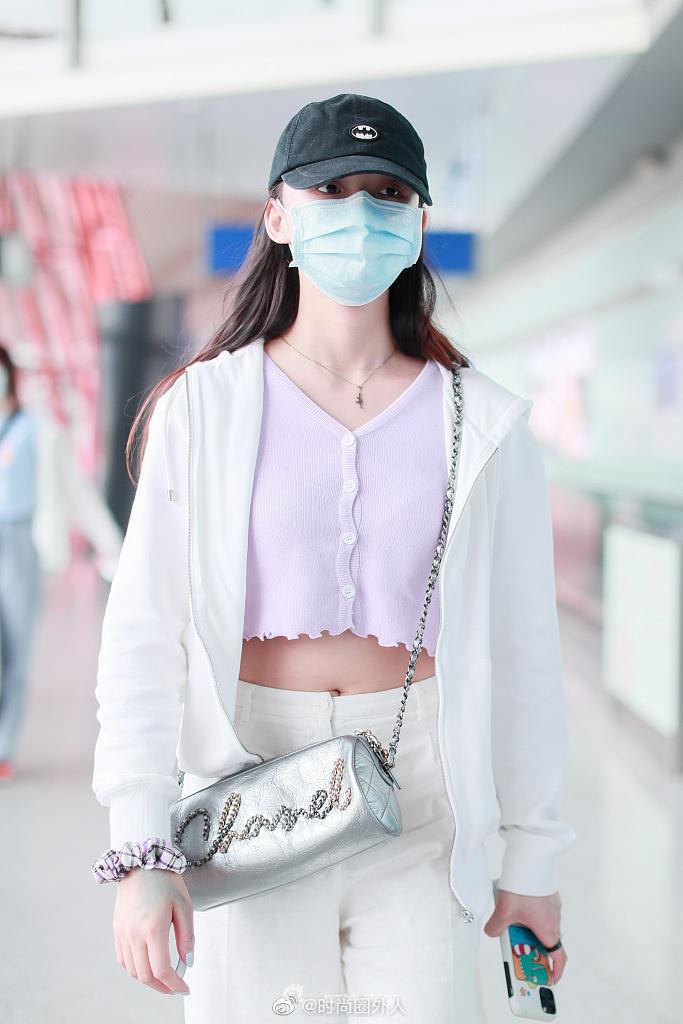 一身白衣搭配露脐装现身机场,长发披肩