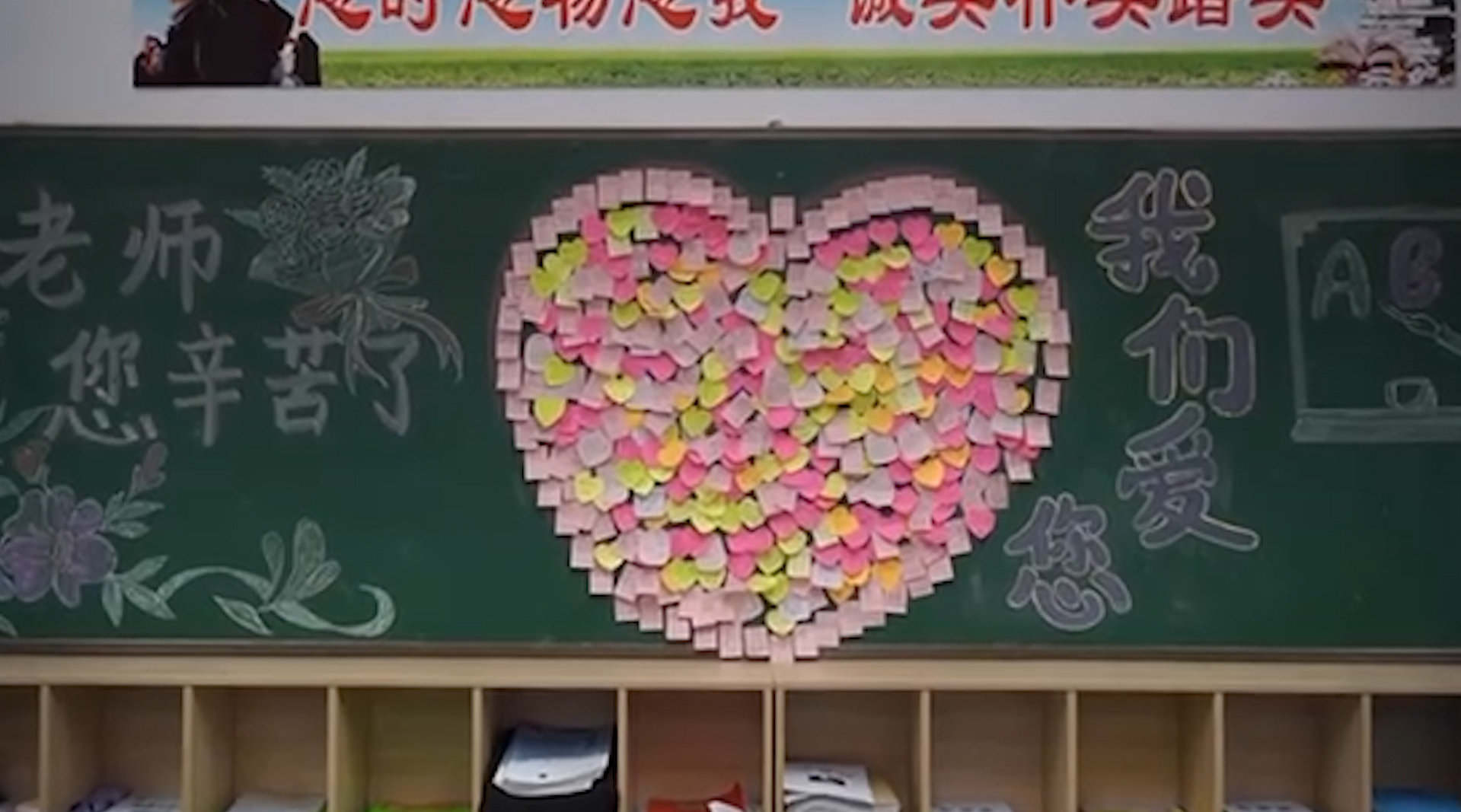 学生在便利贴上写藏头诗,在黑板上拼成爱心向老师表达爱和祝福