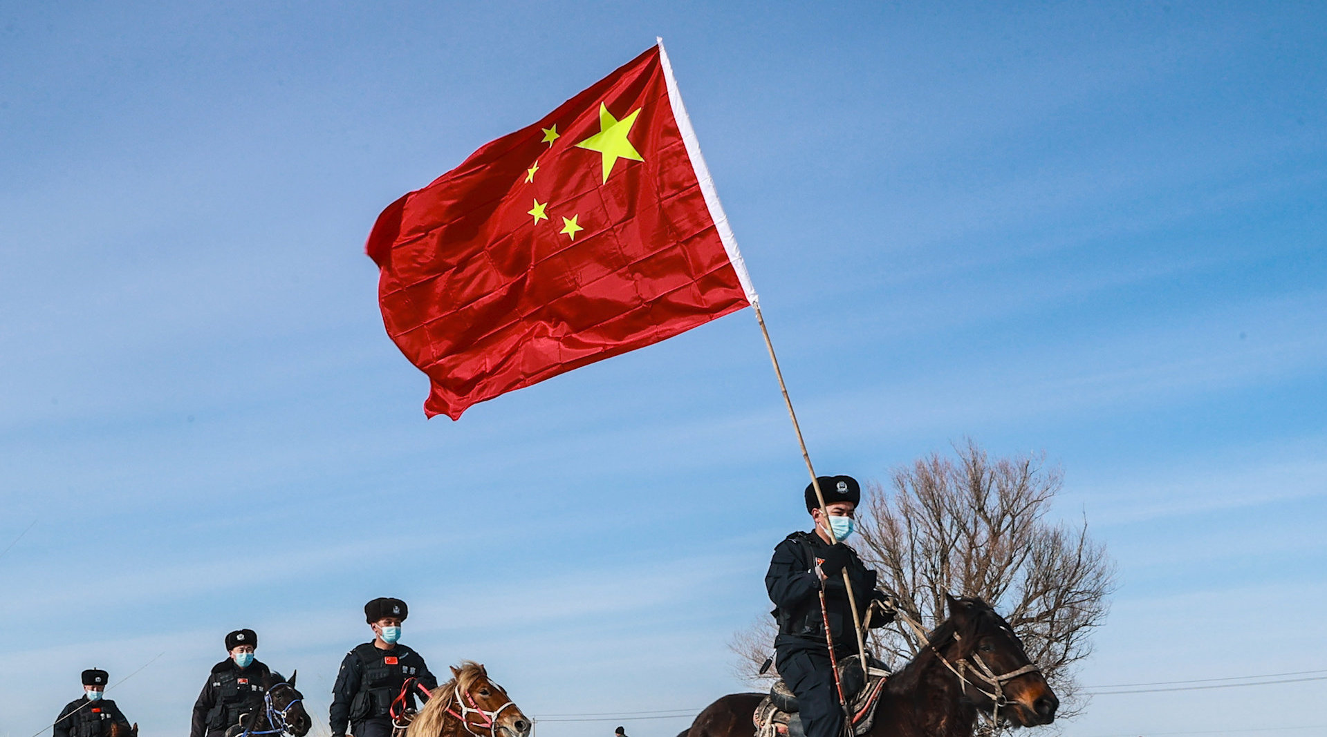 边防民警高举国旗踏雪巡边祝福北京冬奥会圆满成功