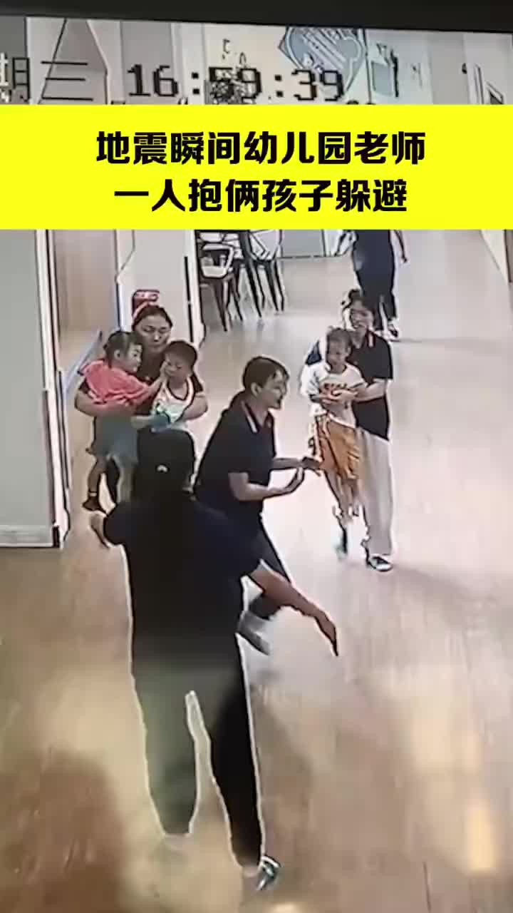 地震瞬间幼儿园老师一人抱俩娃躲避