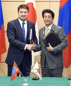 2月10日，日本首相安倍晋三在官邸与来访的蒙古国总理赛汗比勒格(左)举行会谈。图为双方在签署经济伙伴关系协定(EPA)后握手。(共同社)