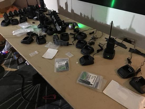  旁边桌上准备足了对讲机好让工作人员随时随地保持联络。