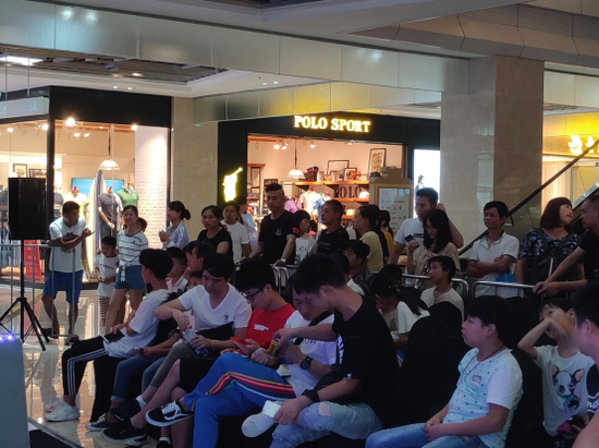 观众们聚集在偌大绿地艺尚魔方的一隅