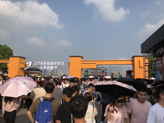 图为在斗鱼直播节入口之一三阳门主舞台附近等待主播演出的游客们