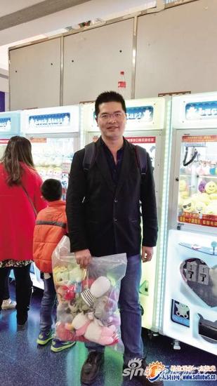 陈志通手里拎着一袋刚夹到的娃娃。