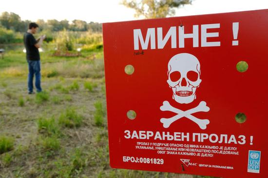 在波斯尼亚的布尔奇科附近，玩家在地雷警告牌旁玩《精灵宝可梦Go》。