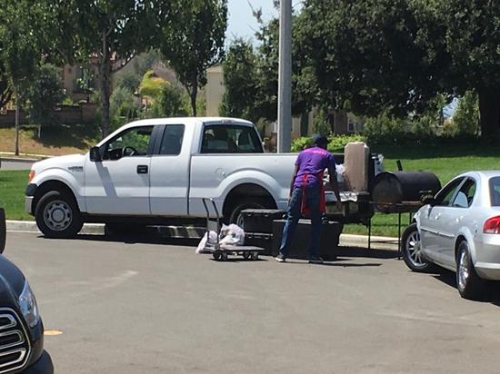 厨师小哥正在搬运他的烧烤用具