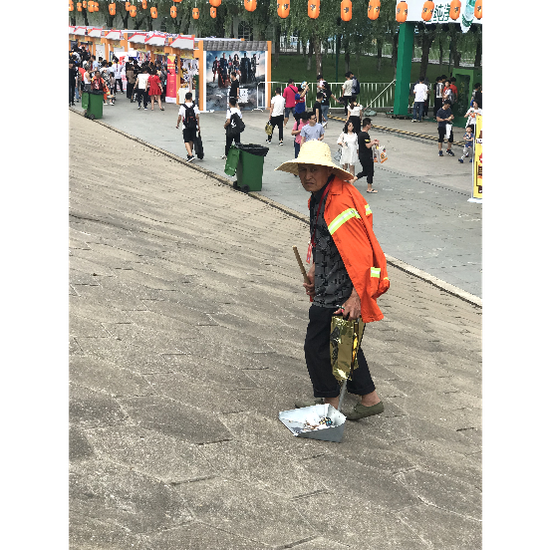 图为干净整洁的园区、正在工作的保洁人员