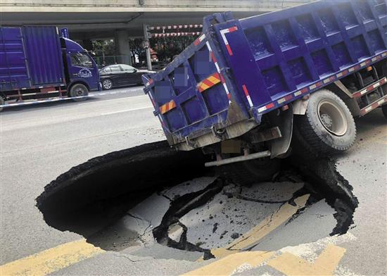 广州番禺大道北突发地陷 一辆货车后轮被"坑"