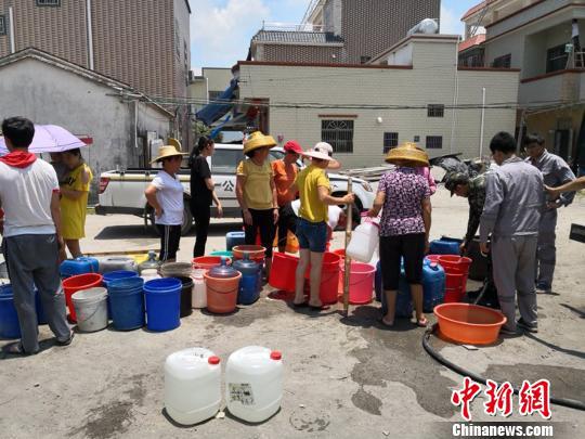 图为当地居民在排队取水 向宇鸣 摄