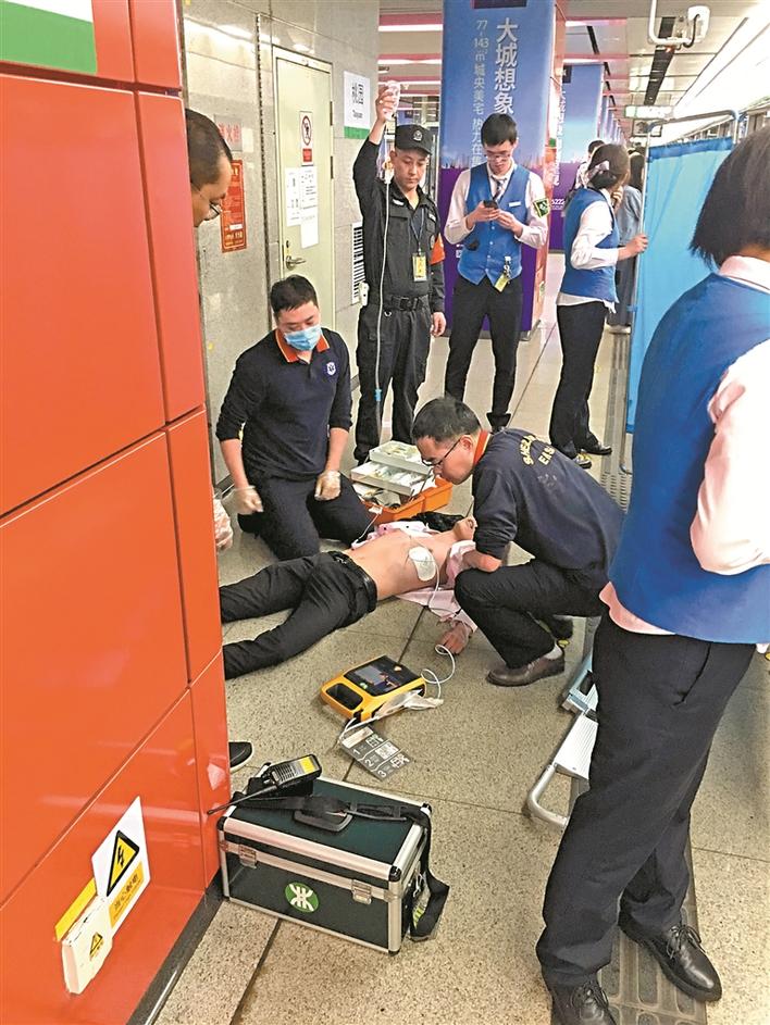 医院急救人员利用地铁站设置的aed对男乘客进行抢救.
