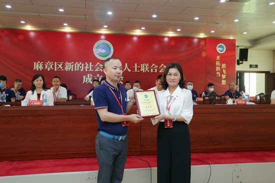 麻章区委副书记,政法委书记林红明向新当选监事长肖安仁颁发证书