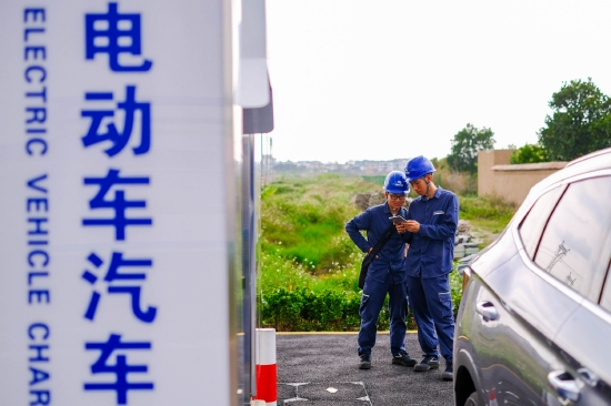 南方电网广东茂名茂南供电局金塘供电所配电运维人员在电动汽车充电站开展运维服务。(庞世俊 摄)