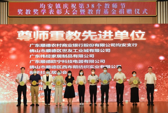龙仲英书记(右一)为尊师重教先进单位颁发荣誉