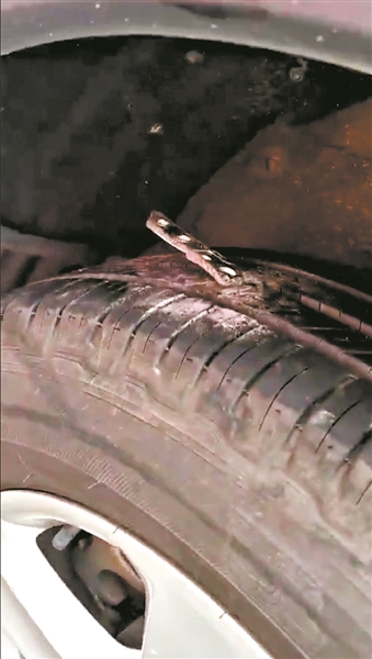 车辆轮胎被散落地上的大量五金配件扎破.