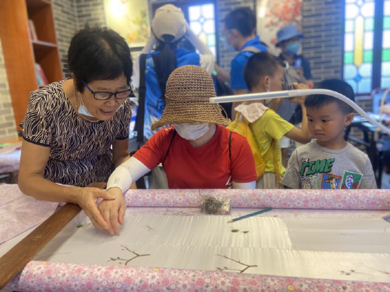 市民在广绣大师指导下体验顺德广绣制作技艺