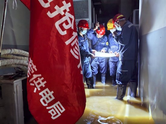 7月11日，南方电网广东东莞供电局支援队伍在贵港盛世荷城小区配电房讨论复电方案。（余日辉 摄）