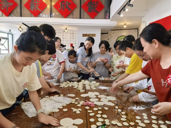 在广州“薛家村”，小朋友在大人带领下做饺子。