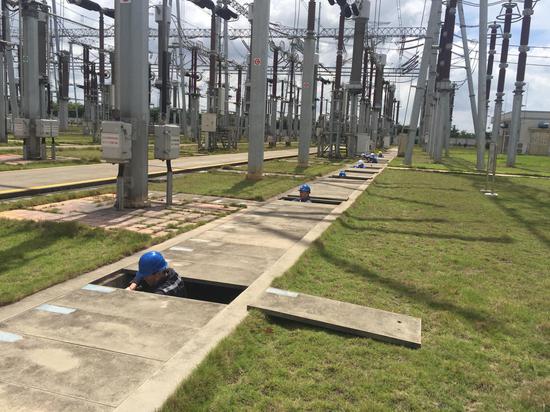 工作人员冒高温齐下电缆沟(黄滢 摄)