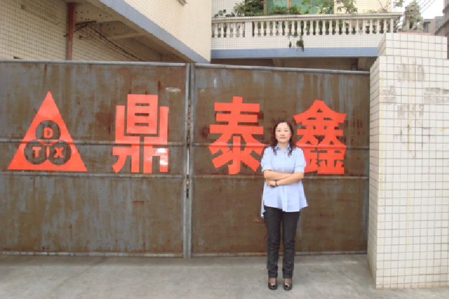 2008年，王馨在工厂门外留影。（受访者供图）
