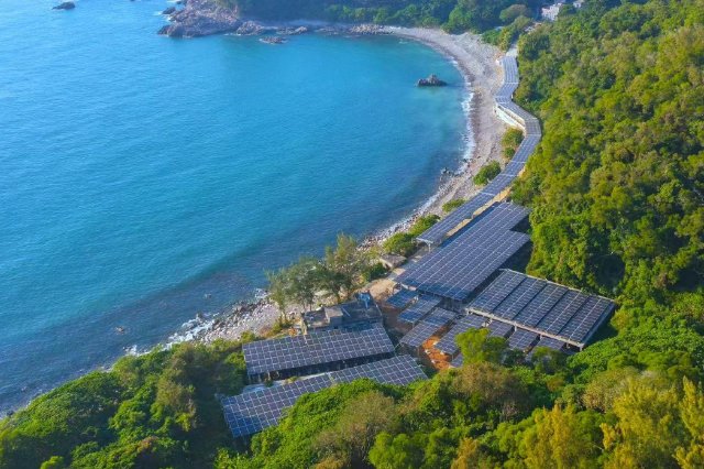 　　碧海青山间，广东三门岛微电网光伏阵列沿沿海岸线铺展，深蓝色光伏板与葱郁山林、湛蓝海岸相映成趣，勾勒出一副美丽的清洁能源新图景。（陈凌 摄）