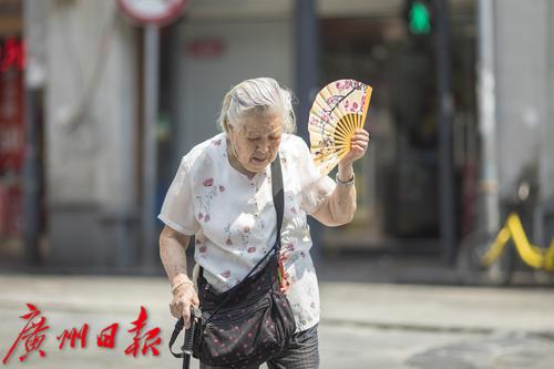 上下九,一位老奶奶用扇子遮阳.