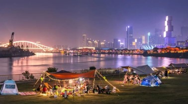图:市民在佛山新城滨河景观带露营。