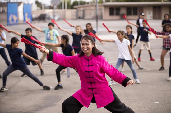 洛杉矶Utah Elementary School的孩子们向来自山东烟台蓬莱市易三实验小学的张培颖老师学习“太极功夫扇”。