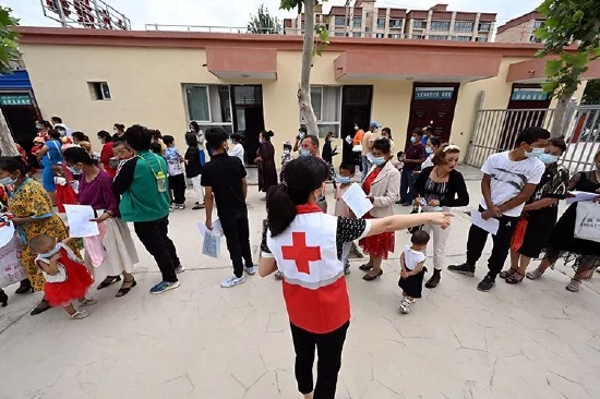 在喀什地区疏附县人民医院筛查点准备筛查的孩子和他们的家长