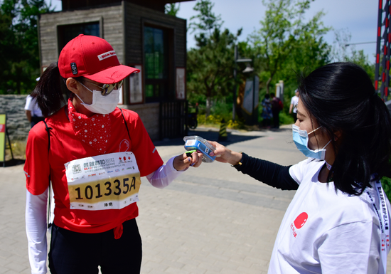 红十字志愿者在活动现场为参赛选手提供补给、路线引导、打卡计时等服务  摄影：谢季森