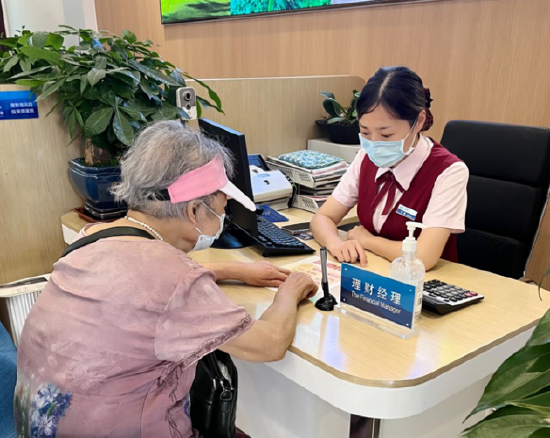 李鑫在长沙高桥社区支行为王奶奶办理业务