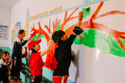 华夏基金志愿者和孩子们一起绘制文化墙