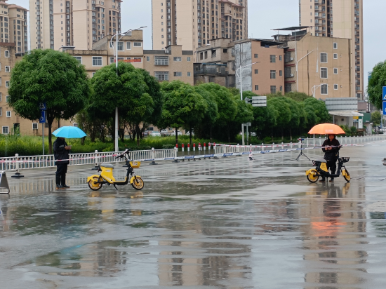 图为 城管人员在涉水路段值守封路，避免市民淌水过街