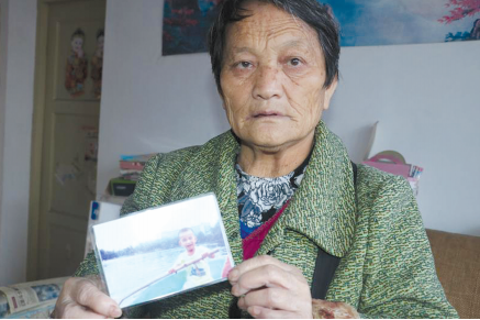 侯玉敏老人拿着走失儿子的照片.