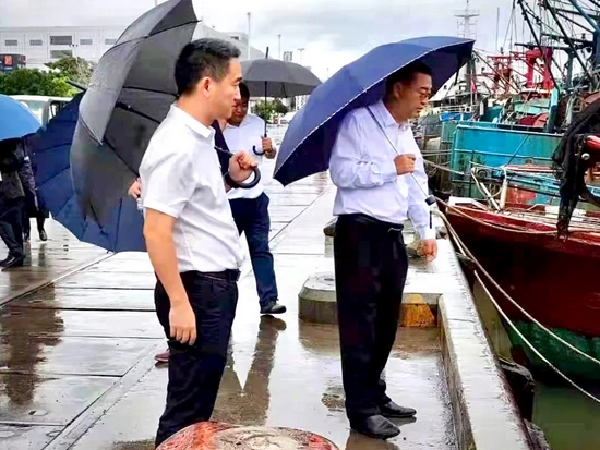马育红(右一,杨剑(左一)在崖州中心渔港现场检查台风防御工作