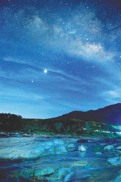 盛夏夜晚星空下的琼中和平镇乘坡河石臼地质奇观,溪流倒映着星星