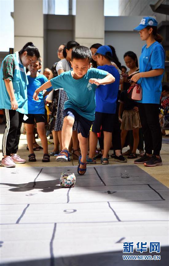 6月1日,小朋友在海南省博物馆跳房子.新华社记者 郭程 摄