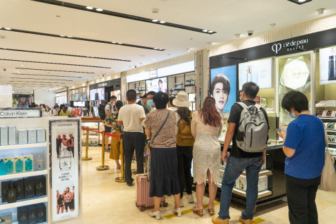 (旅客在海口美兰机场免税店排队购物)