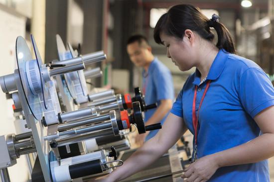 海口美兰机场免税店物流部理货员对免税品进行贴标