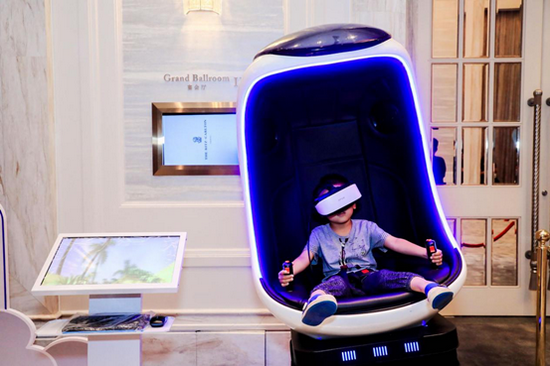 观展的小朋友坐在互动区的太空椅上,通过神奇的vr装备"现场观看"航天