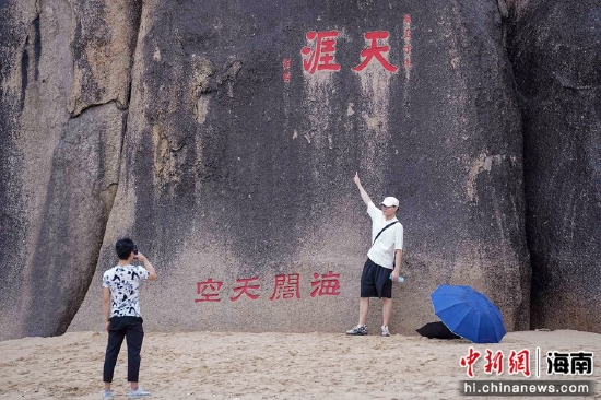 图为游客在三亚天涯海角景区的“天涯石”前拍照留念。骆云飞摄