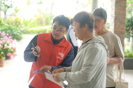 海南电网公司五指山供电局工作人员为“候鸟“旅客讲解冬季安全用电知识。吴翔 摄