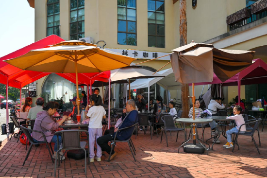 游客在福山咖啡文化风情镇旅游区内小憩，品尝咖啡和特色美食。