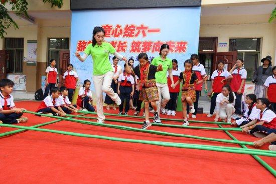 5月29日，在三亚市崖州区赤草小学，三亚南山景区员工和学生们在跳竹竿舞。