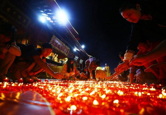 2月9日，人们在三亚南山文化旅游区内的南山寺点燃蜡灯祈福
