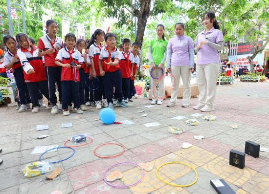 5月29日，在三亚市崖州区赤草小学，三亚南山景区和学生们在参加套圈游戏。