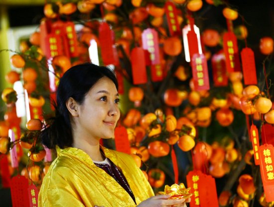 2月9日，一游客在三亚南山文化旅游区祈愿树前祈愿、拍照