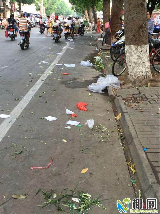 摊贩留下一地的烂菜叶,垃圾袋